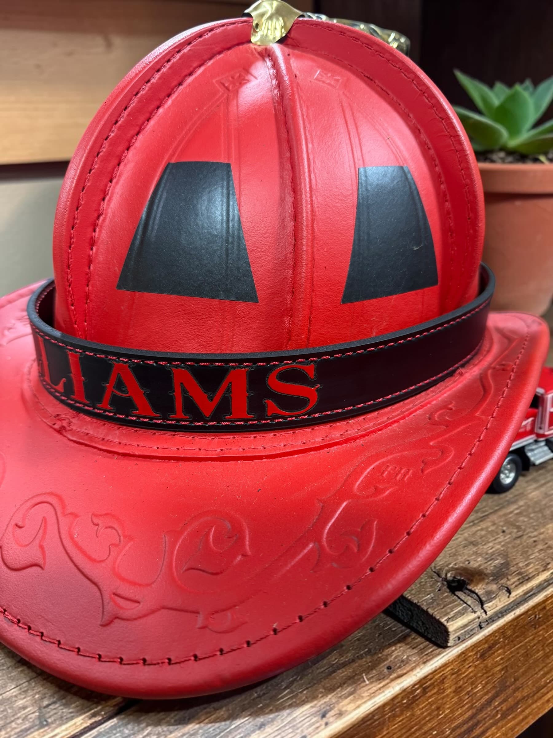 Side view of a custom firefighter helmet band on a leather fire helmet — view 3